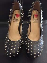 Sapatos de senhora pretos com apliques de metal dourados.