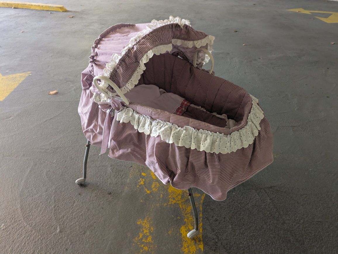 Alcofa antiga com suporte e roupa