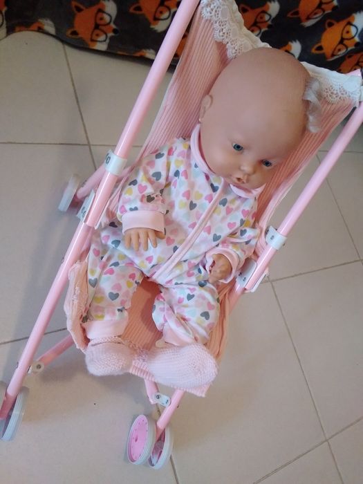 Bebé no carrinho rosa.