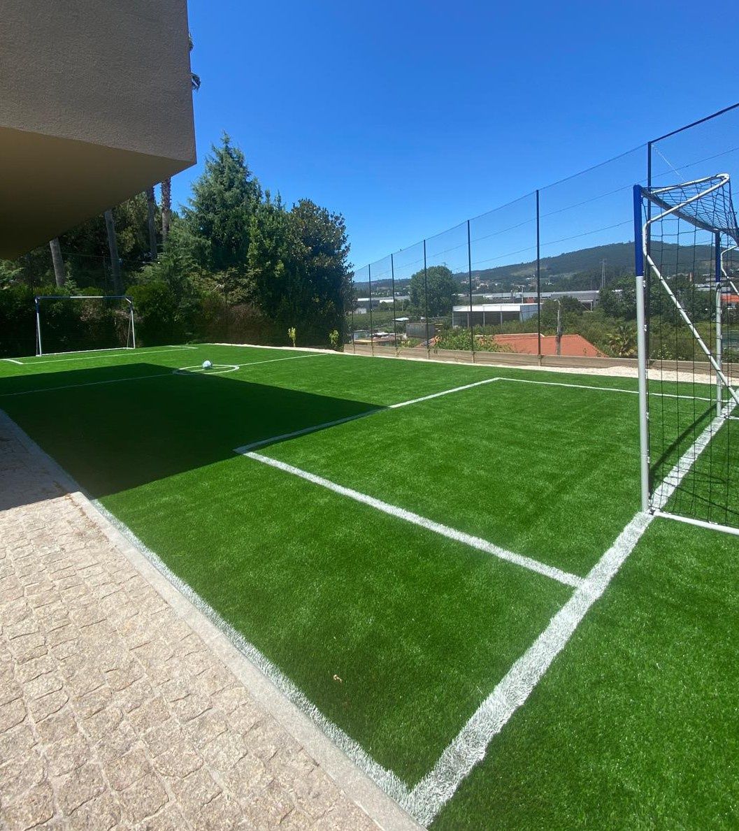 Espaço exterior com piscina e campo de jogos.