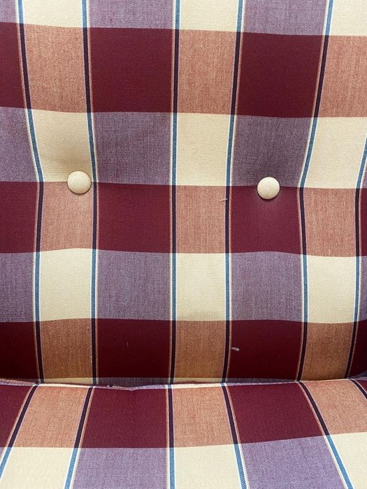 Poltrona vintage de orelhas com estampa xadrez.