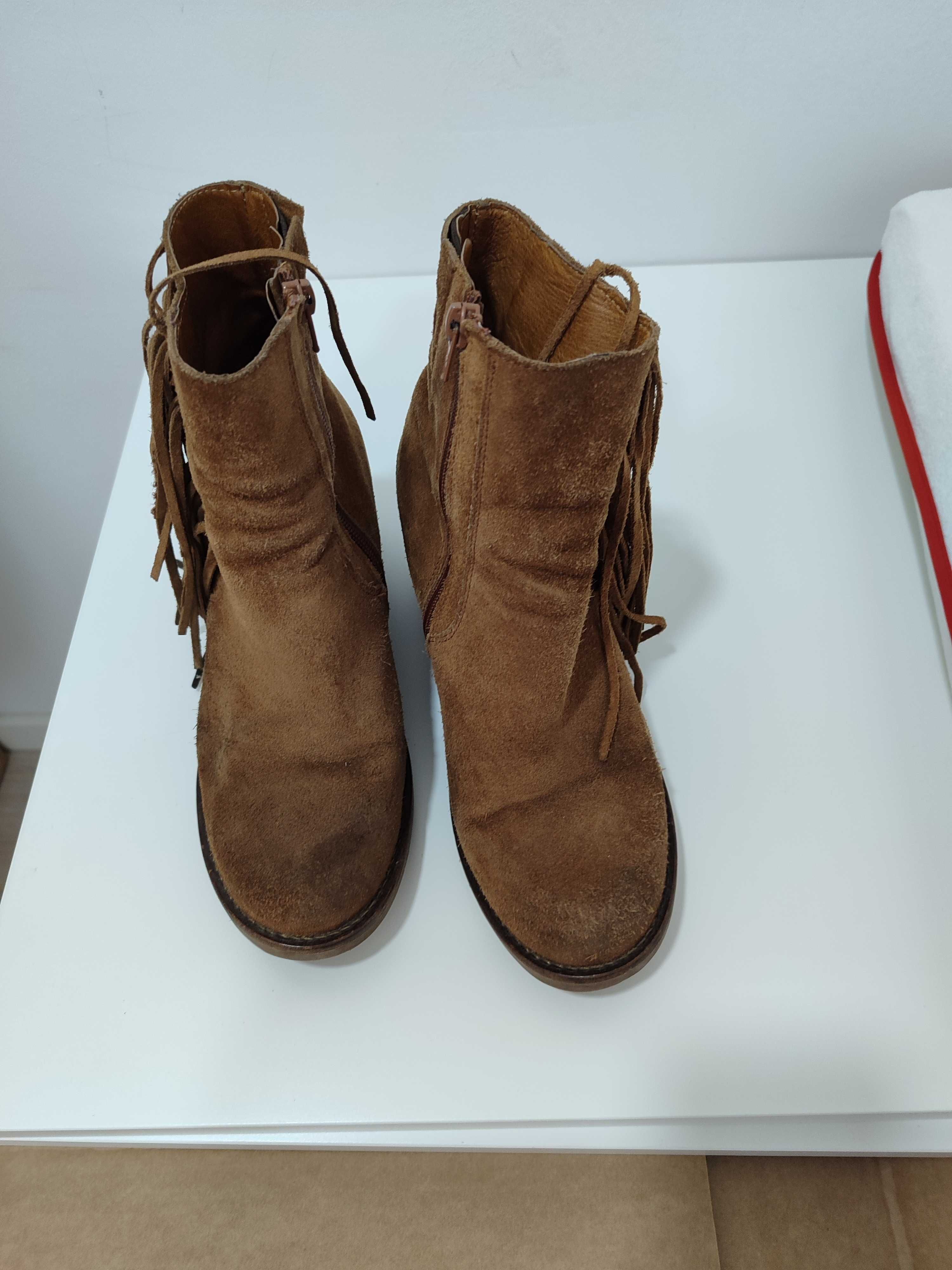 Botas de mulher castanhas com franjas e fecho de lado.