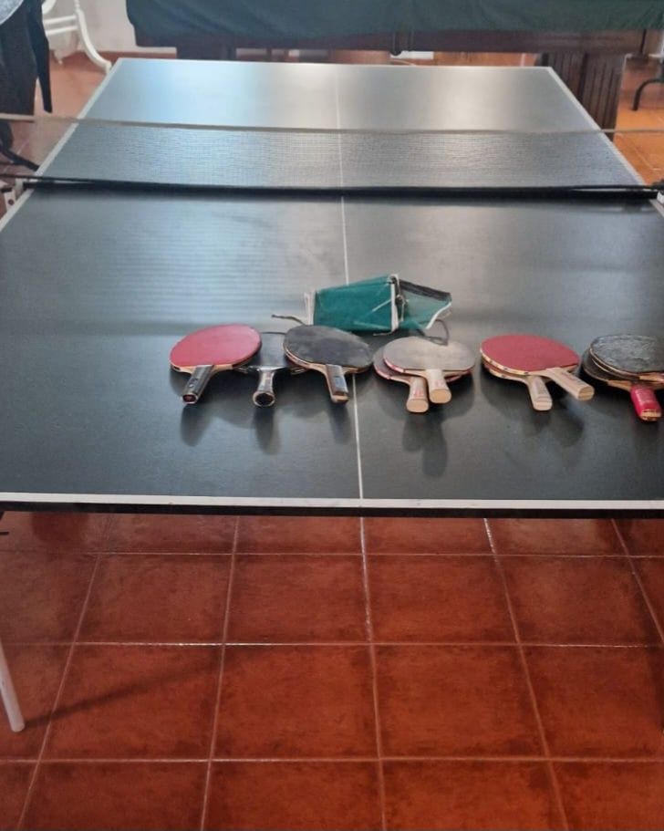 Mesa de ping pong com várias raquetes