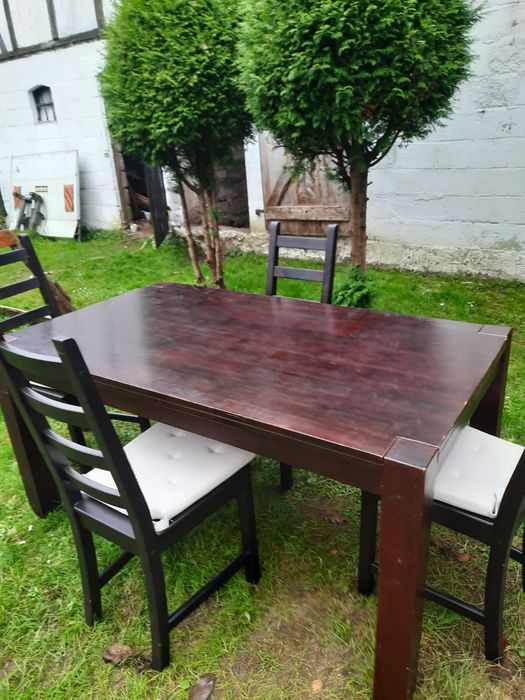 Solidny stół z 4 krzesłami.