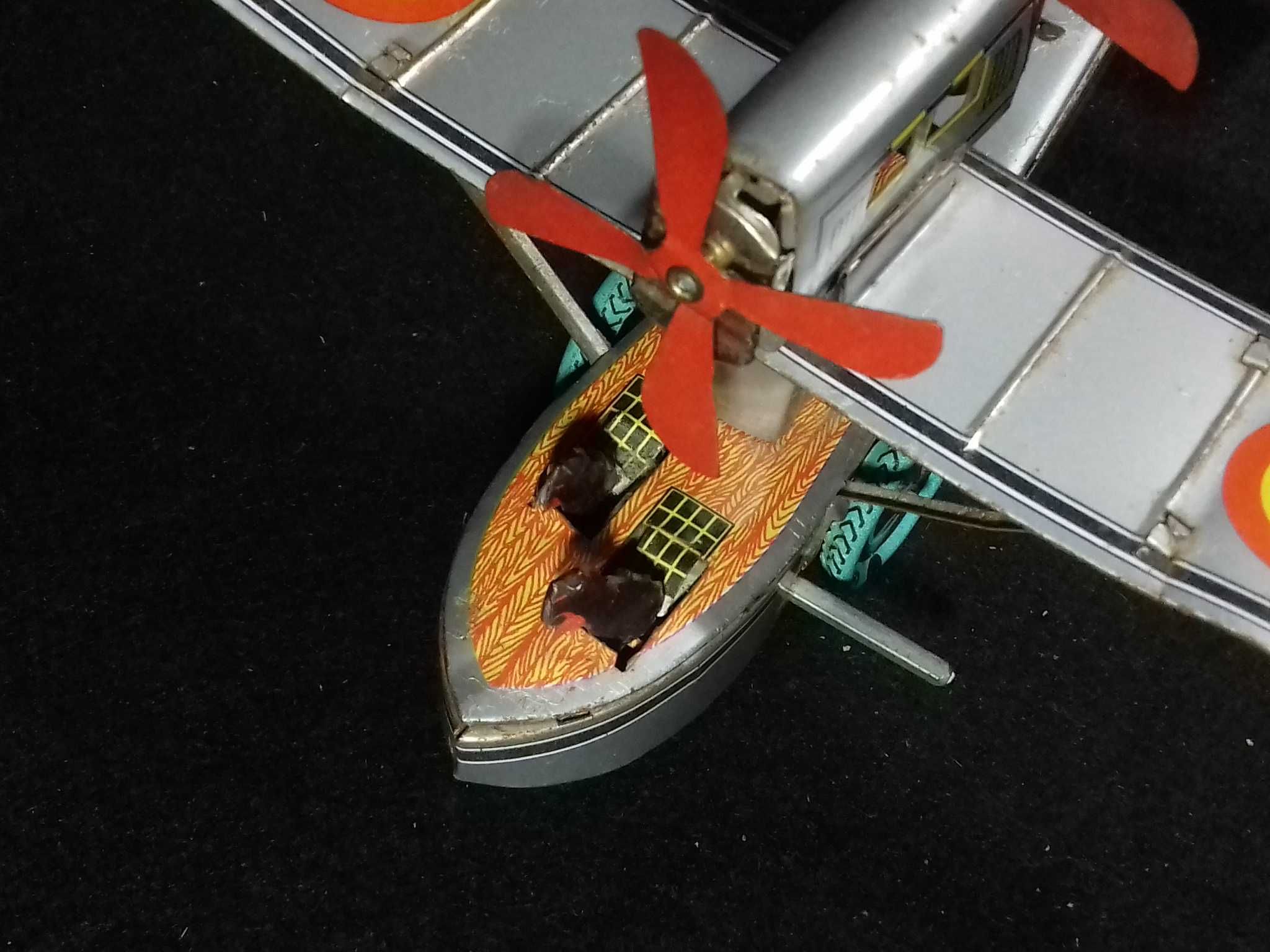 Miniatura de avião antigo em metal, com sistema mecânico de corda;