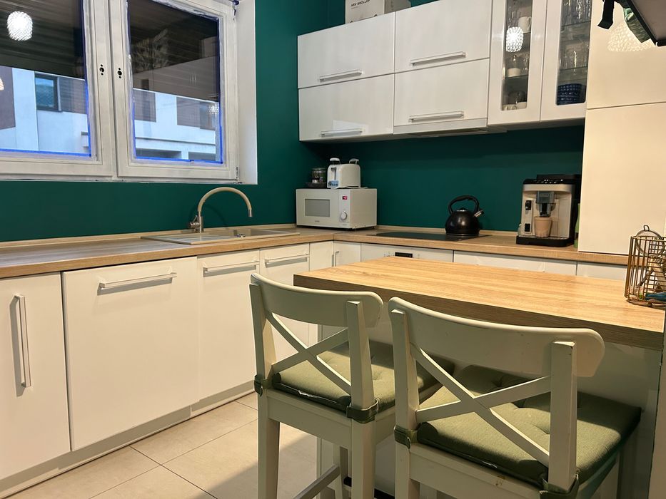 Kuchnia z wyspą kuchenną i krzesłami