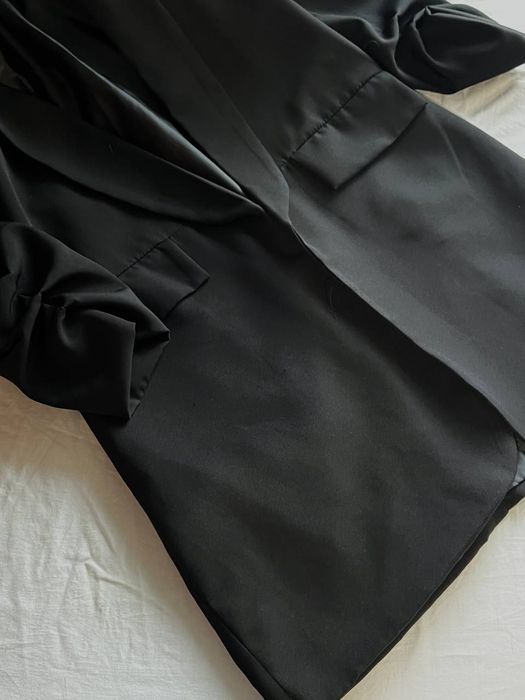 Елегантний подовжений чорний піджак.