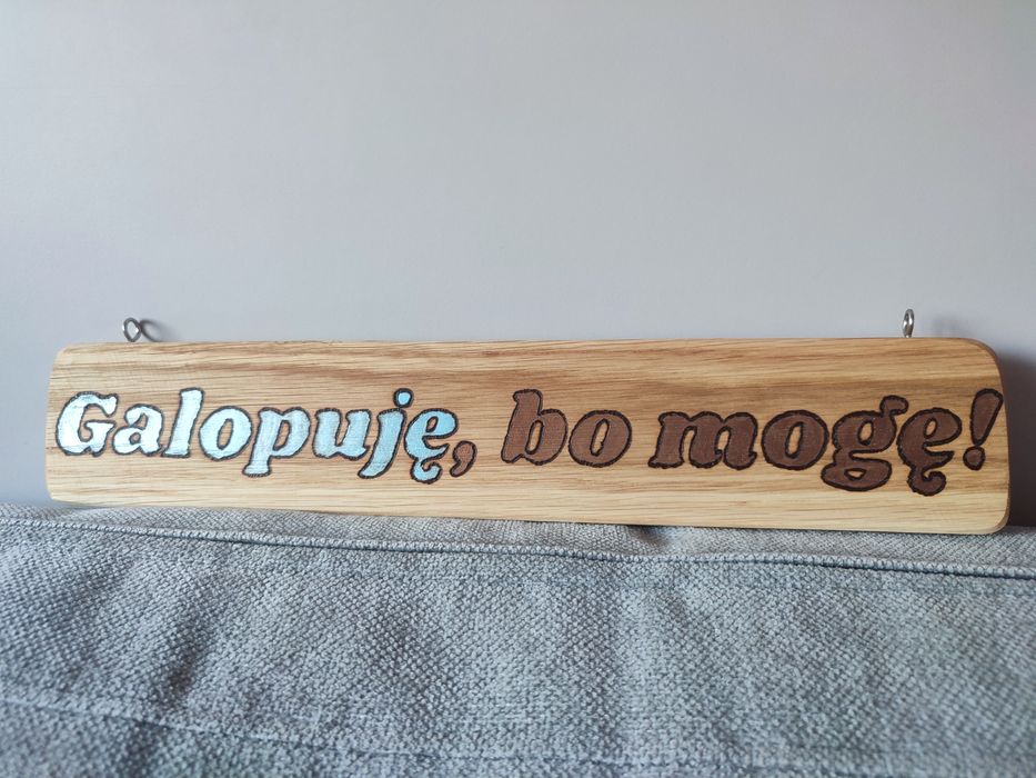 Drewniana tabliczka zawieszana z napisem: Galopuję, bo mogę.