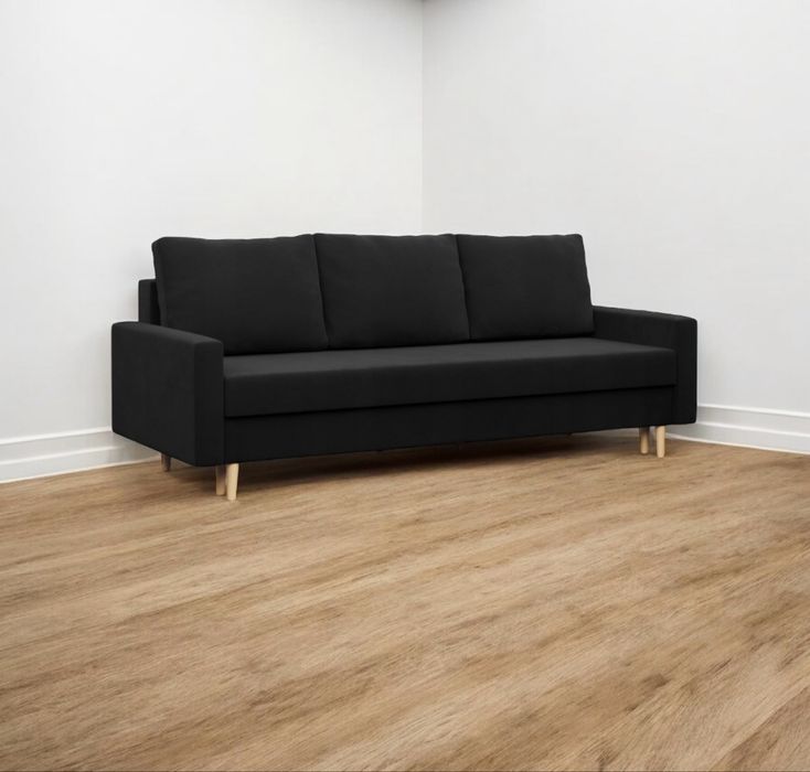 Używana czarna sofa rozkładana z funkcją spania pojemnikiem. Transport