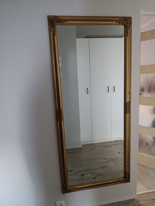 Duże lustro w złotej ramie