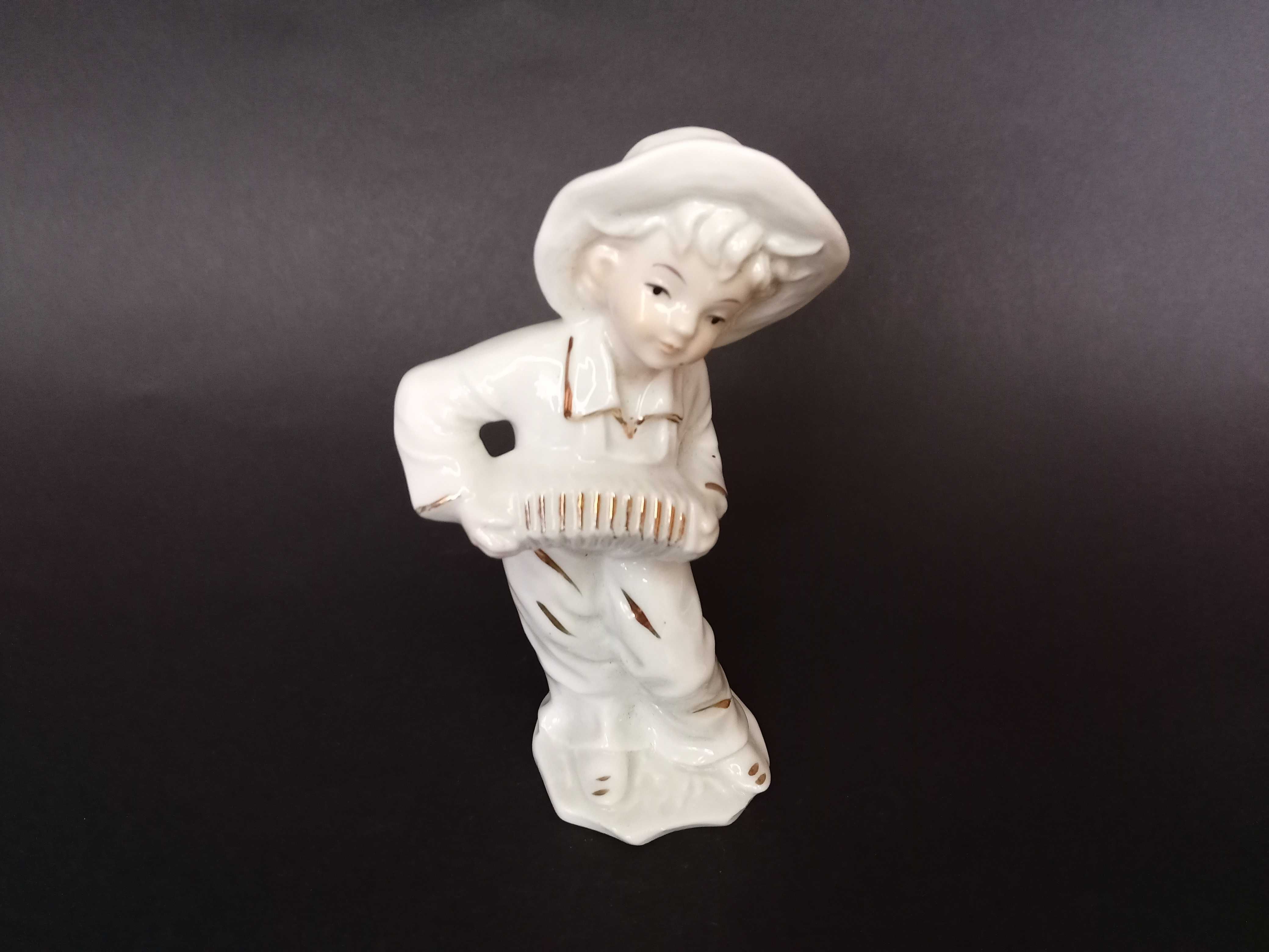 Ceramiczna figurka chłopiec z harmonią