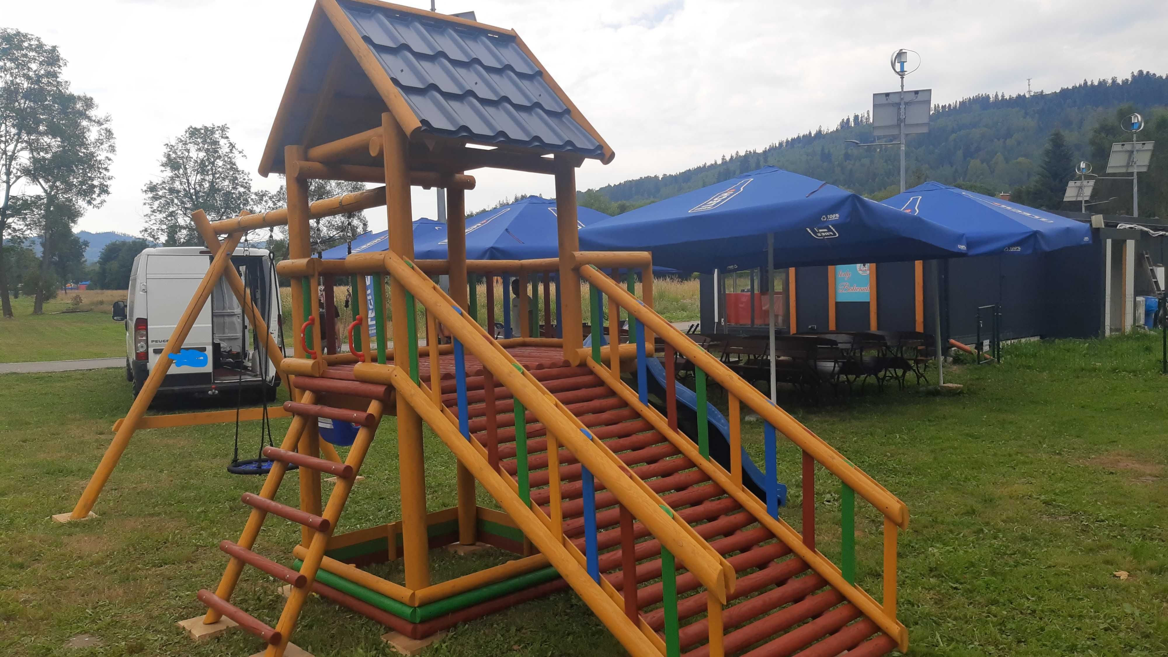 Plac zabaw dla dzieci zjeżdżalnia  huśtawki domek drewniany z drabinką