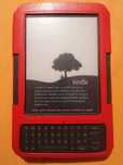 czytnik e-booków Amazon Kindle Keyboard w czerwonym etui.