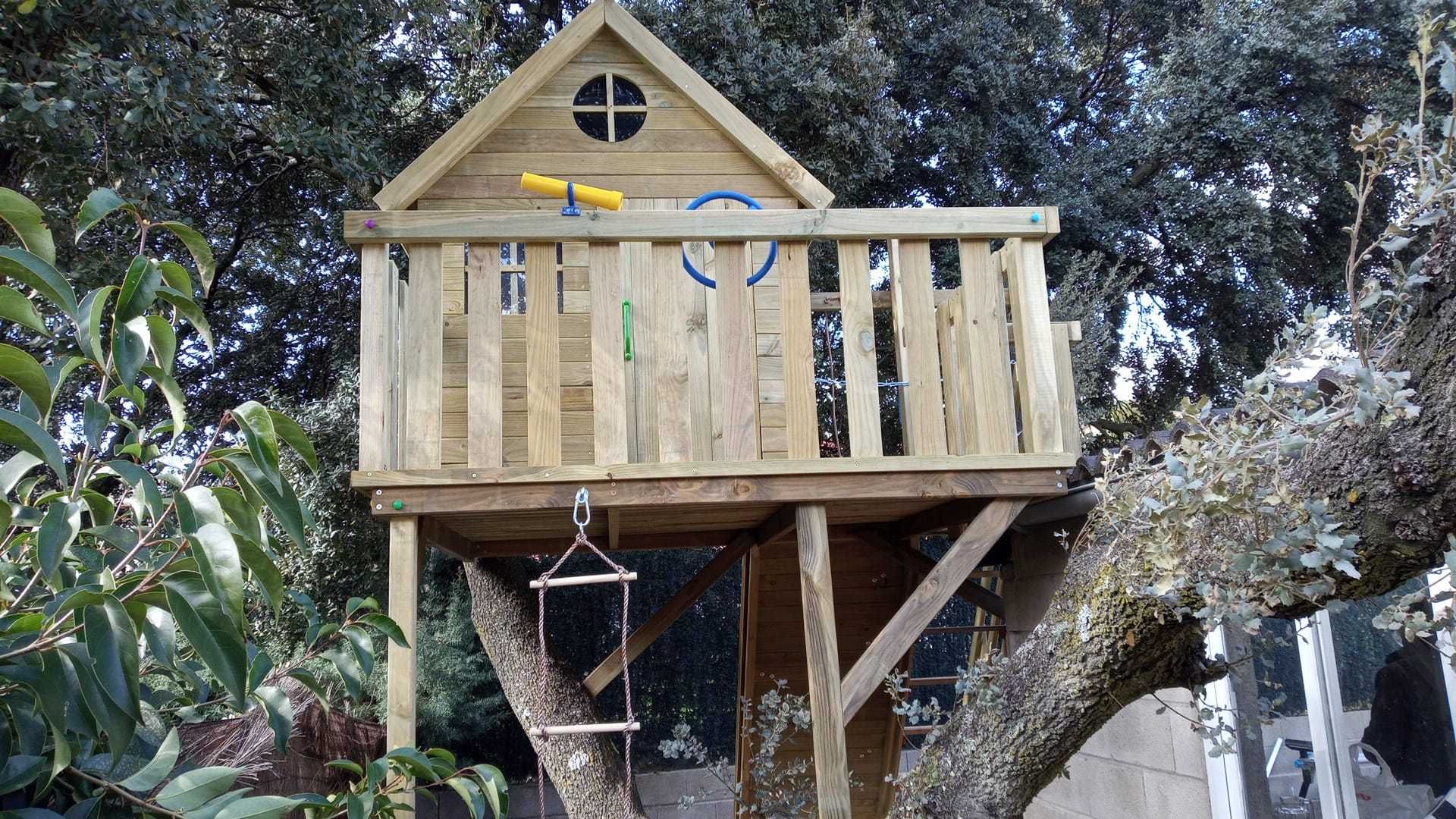 Casinha na árvore com parede de escalada