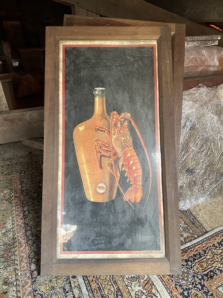 Quadro de lagosta com garrafa de barro.