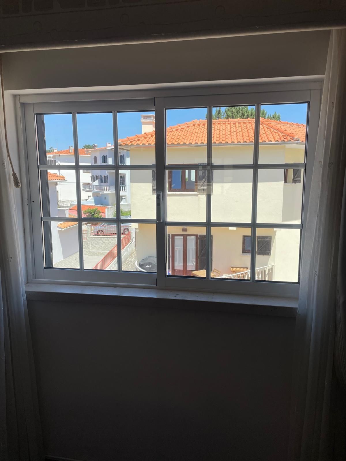 Duas janelas de abrir, em alumínio branco.