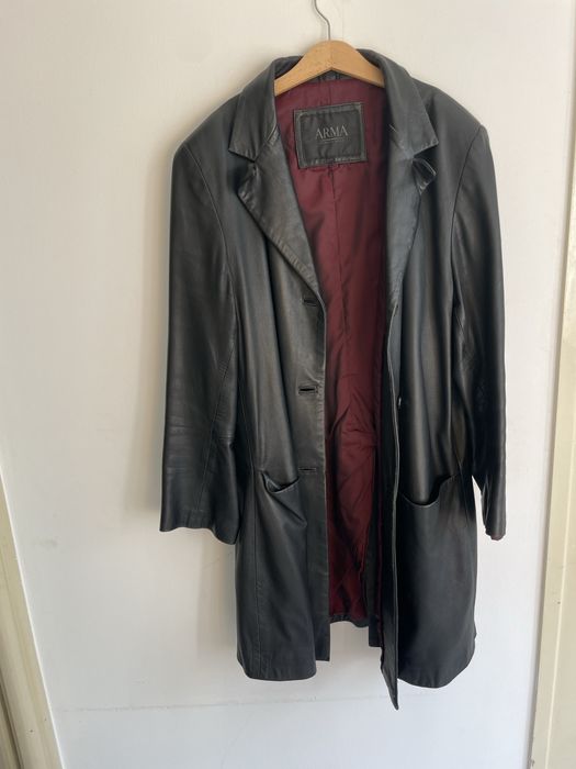 Casaco comprido de cabedal preto.