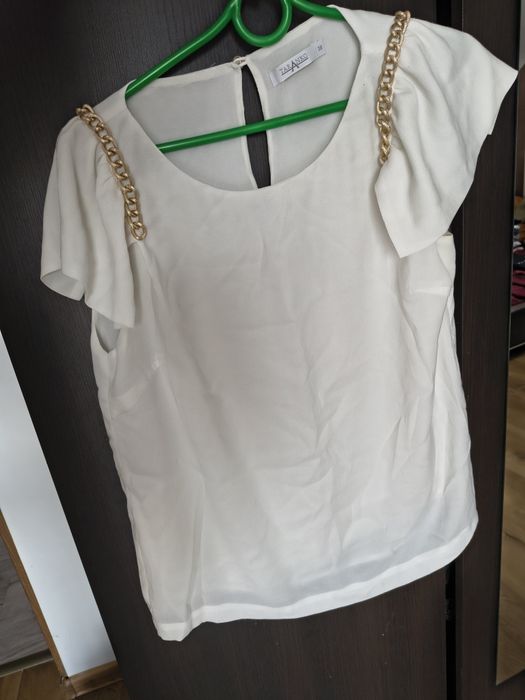 Elegancka ecru bluzka ze złotymi łańcuszkami falbany na ramionach