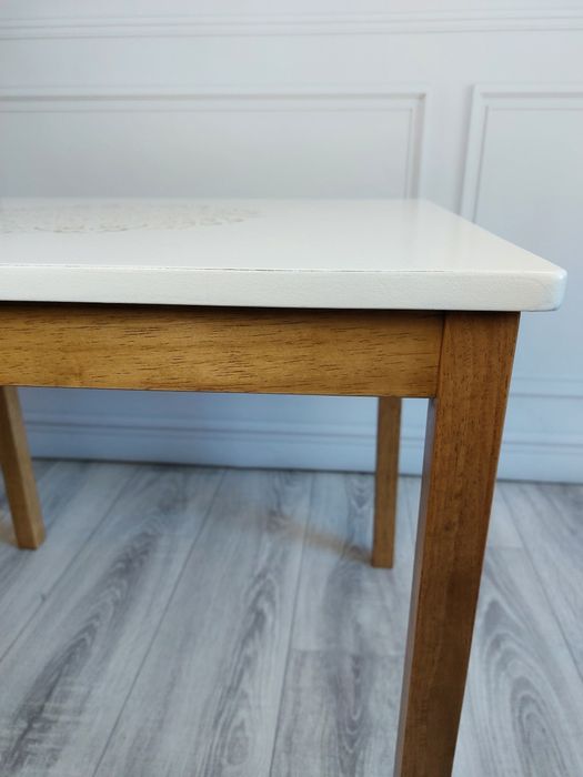 Biały stolik kawowy z drewnianymi nogami