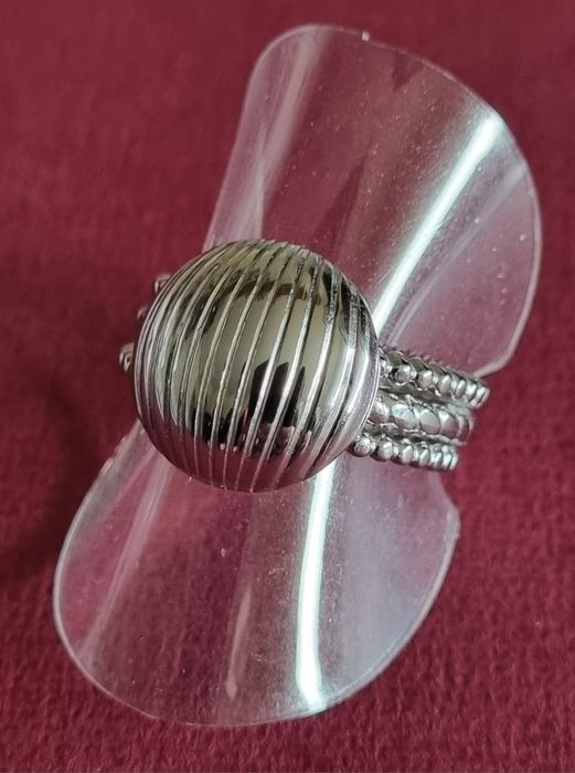 Anel prateado, em aço, com meia bola riscada. Ajustável