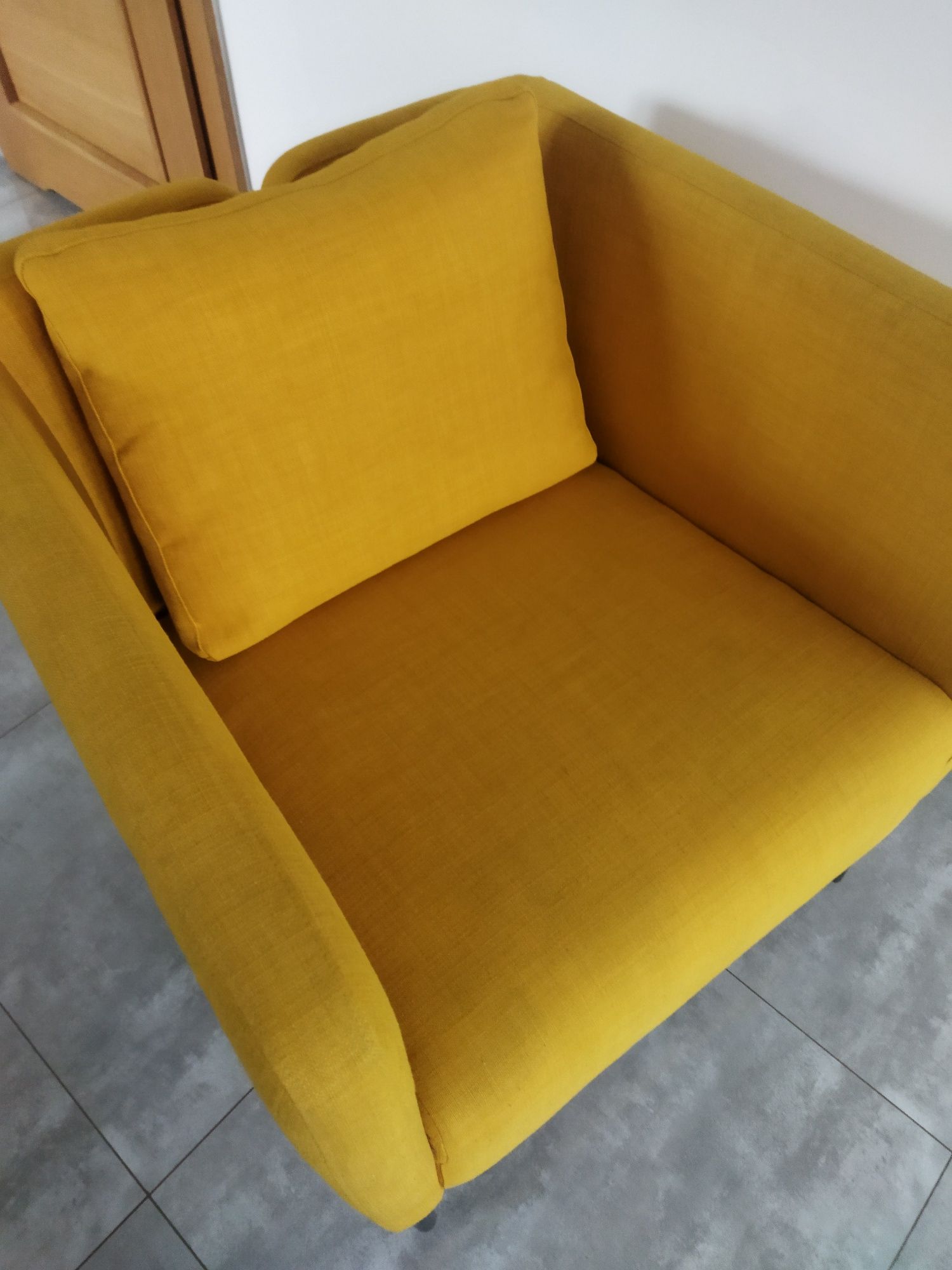 Żółty fotel na wysokich nóżkach