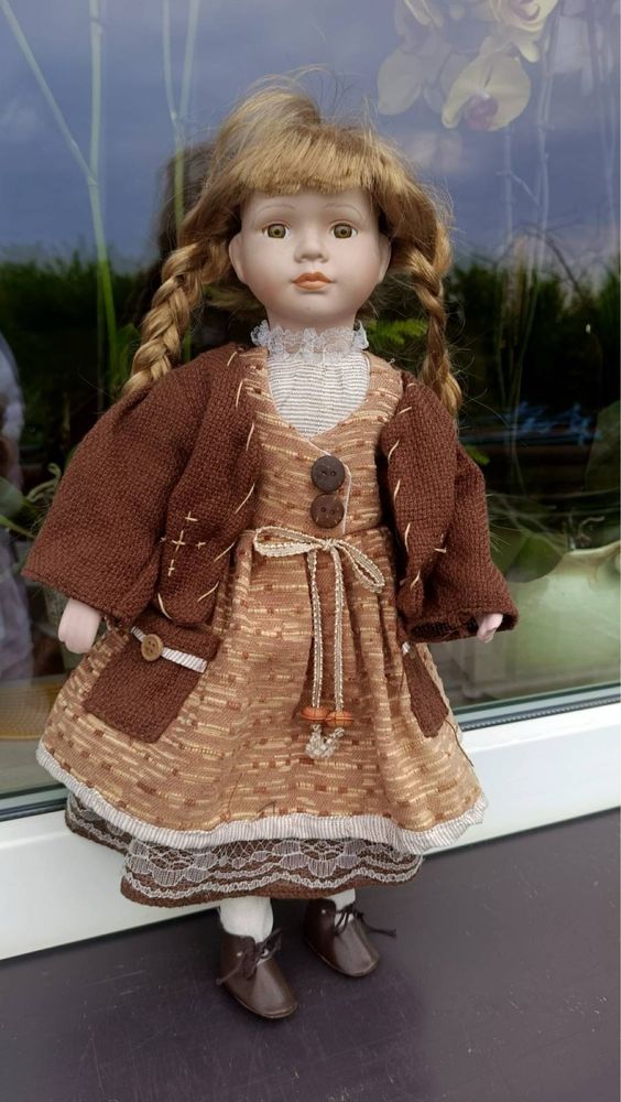 Porcelanowa lalka w brązowej sukience