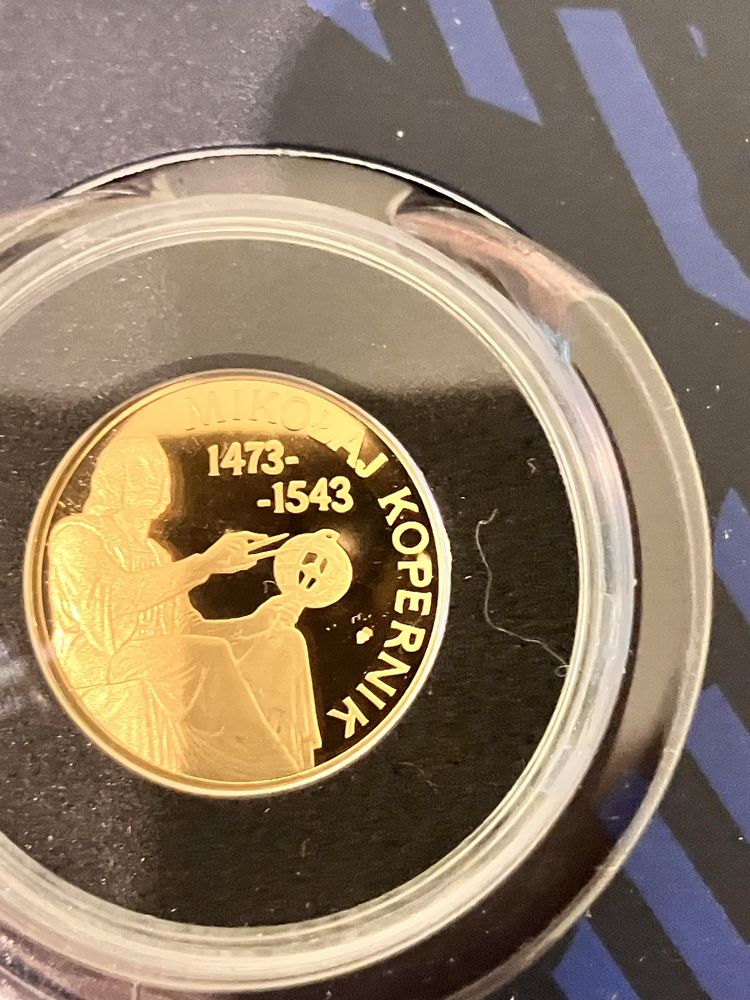 Złoty medal z Mikołajem Kopernikiem i pozłacani polscy naukowcy .