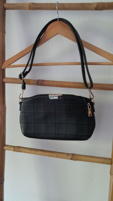 Mala preta e dourada em material sintético