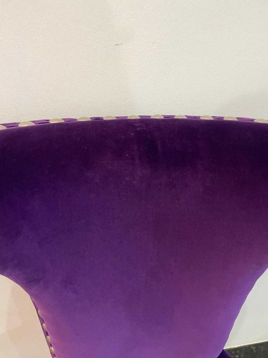 Cadeira moderna em veludo roxo com tachas metálicas de exposição