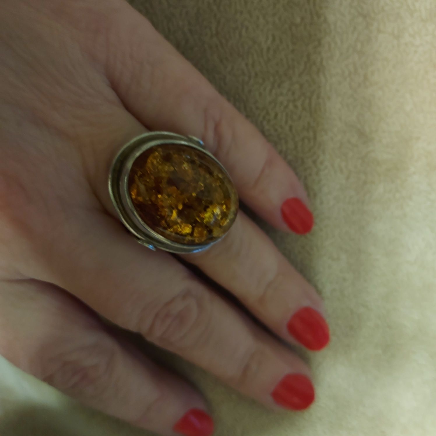 Duzy srebrny pierścionek ze złocistym bursztynem.
