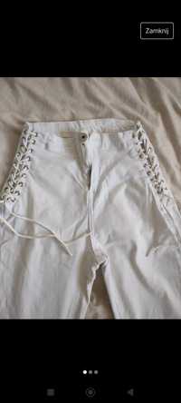 Białe spodnie z rzemykami po bokach