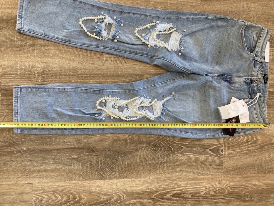 Spodnie z dziurami i perłami