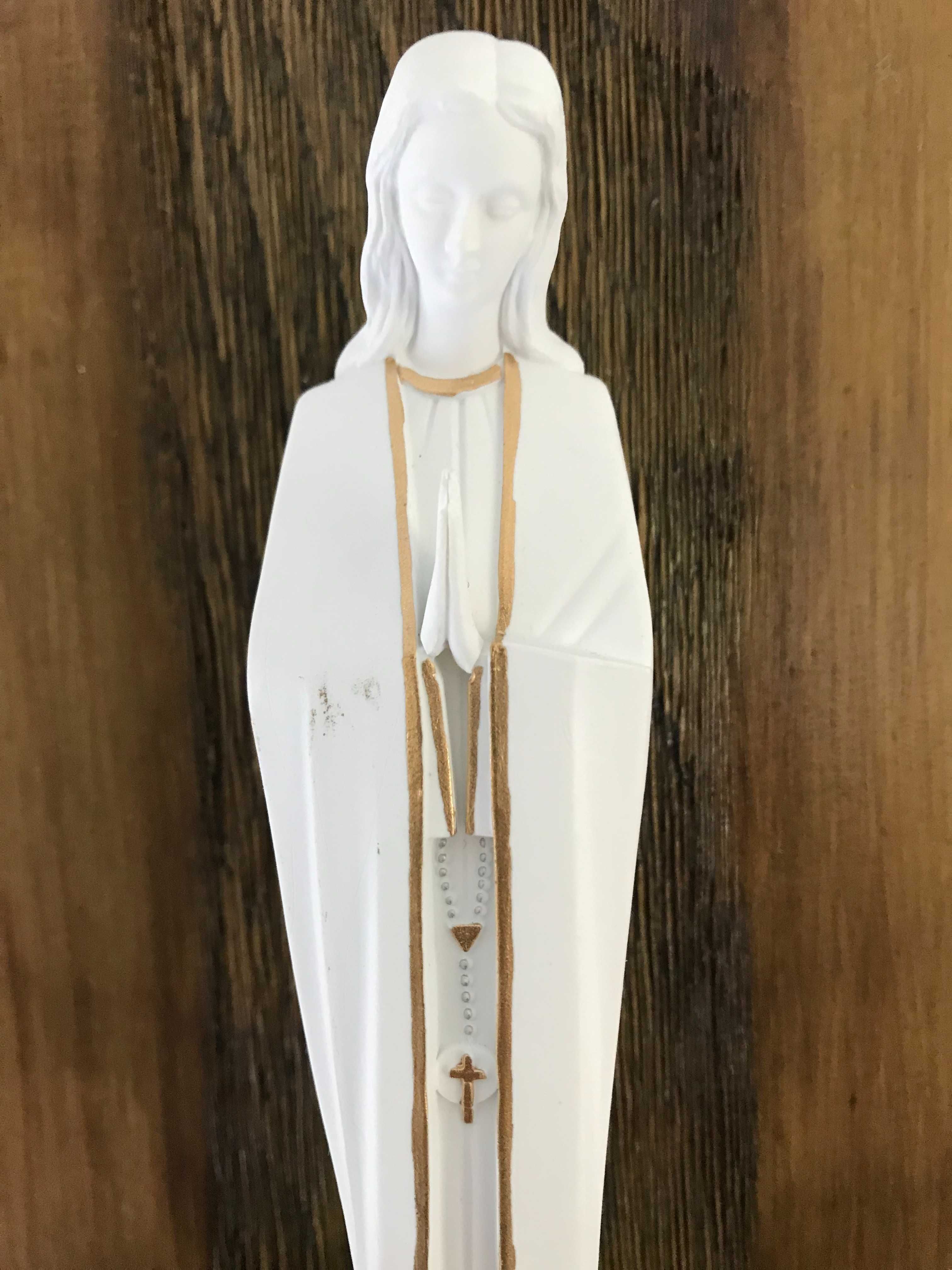 Estatueta da Virgem Maria em uma prateleira de madeira