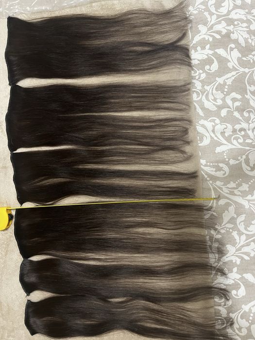 Extensões castanhas escuras de cabelo verdadeiro.
