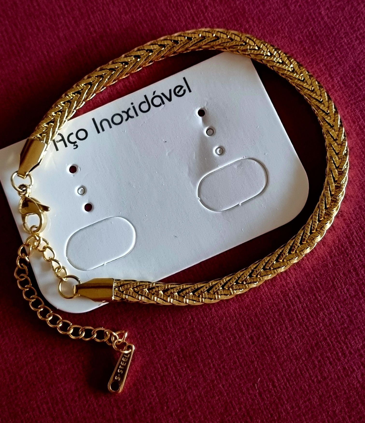 Pulseira dourada, em aço inoxidável. Tem extensor