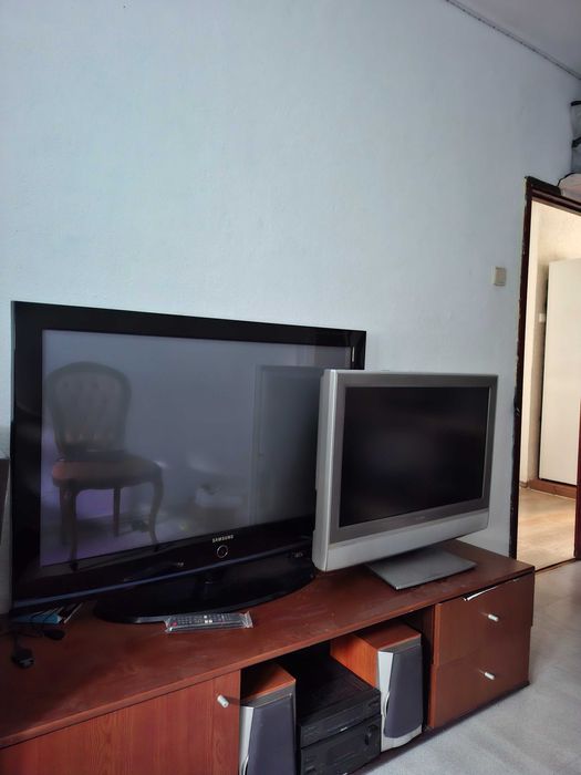 Duas TV LCD um sofa carpete e presépio