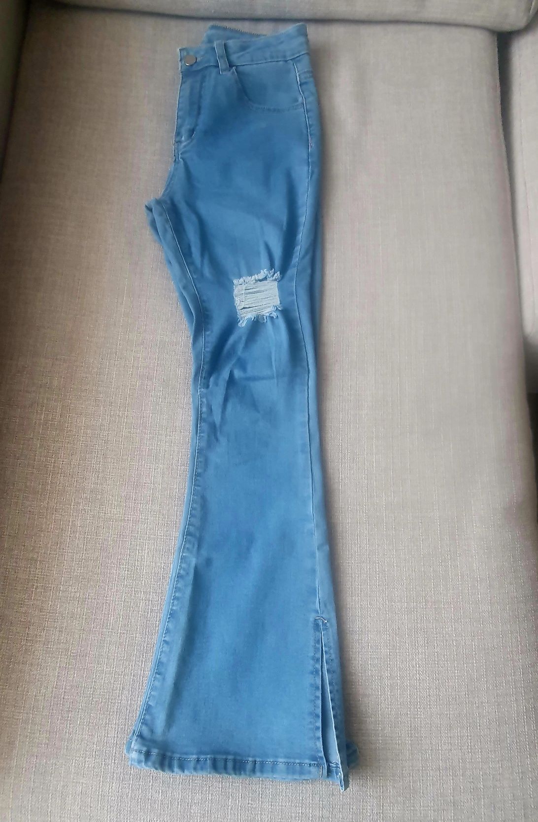 Calça de ganga cintura subida e boca de sino com abertura no fundo