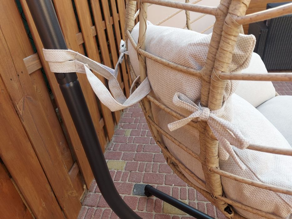 Fotel wiszący na stalowej podstawie z poduszką.