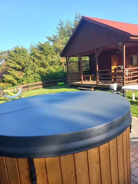 domek z kominkiem i balią z jacuzzi nad jeziorem