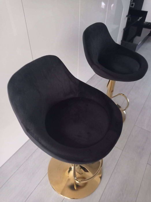 Dwa czarne hokery na zlotej podstawie regulowane