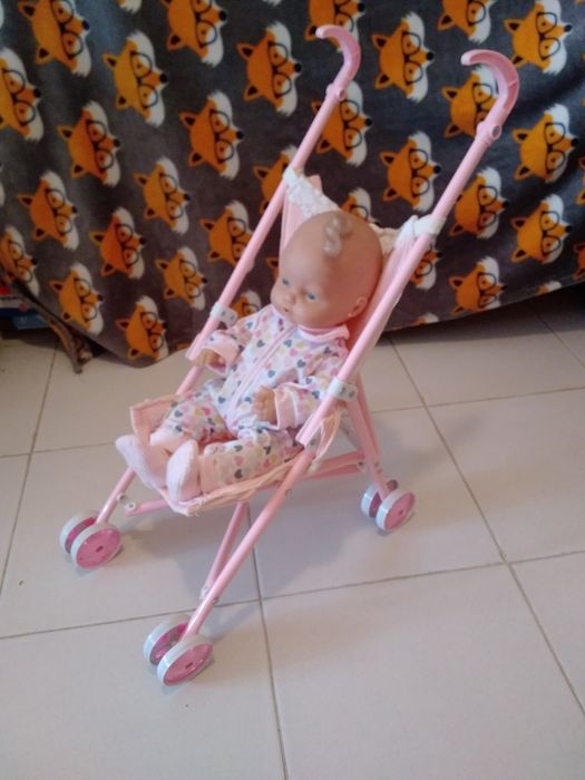 Bebé no carrinho rosa.