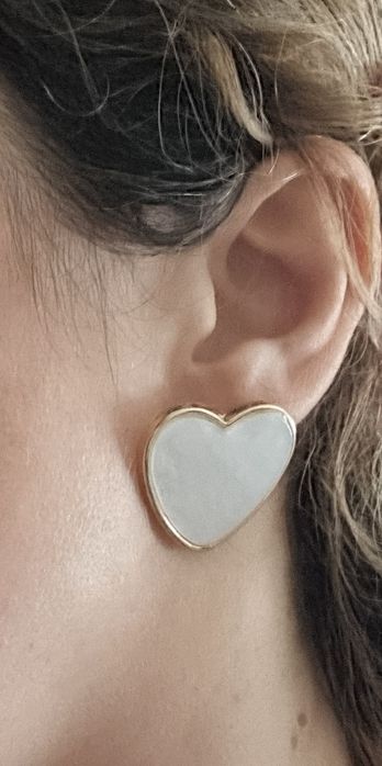 Brincos, de picos, com forma de coração branco delineado a dourado.
