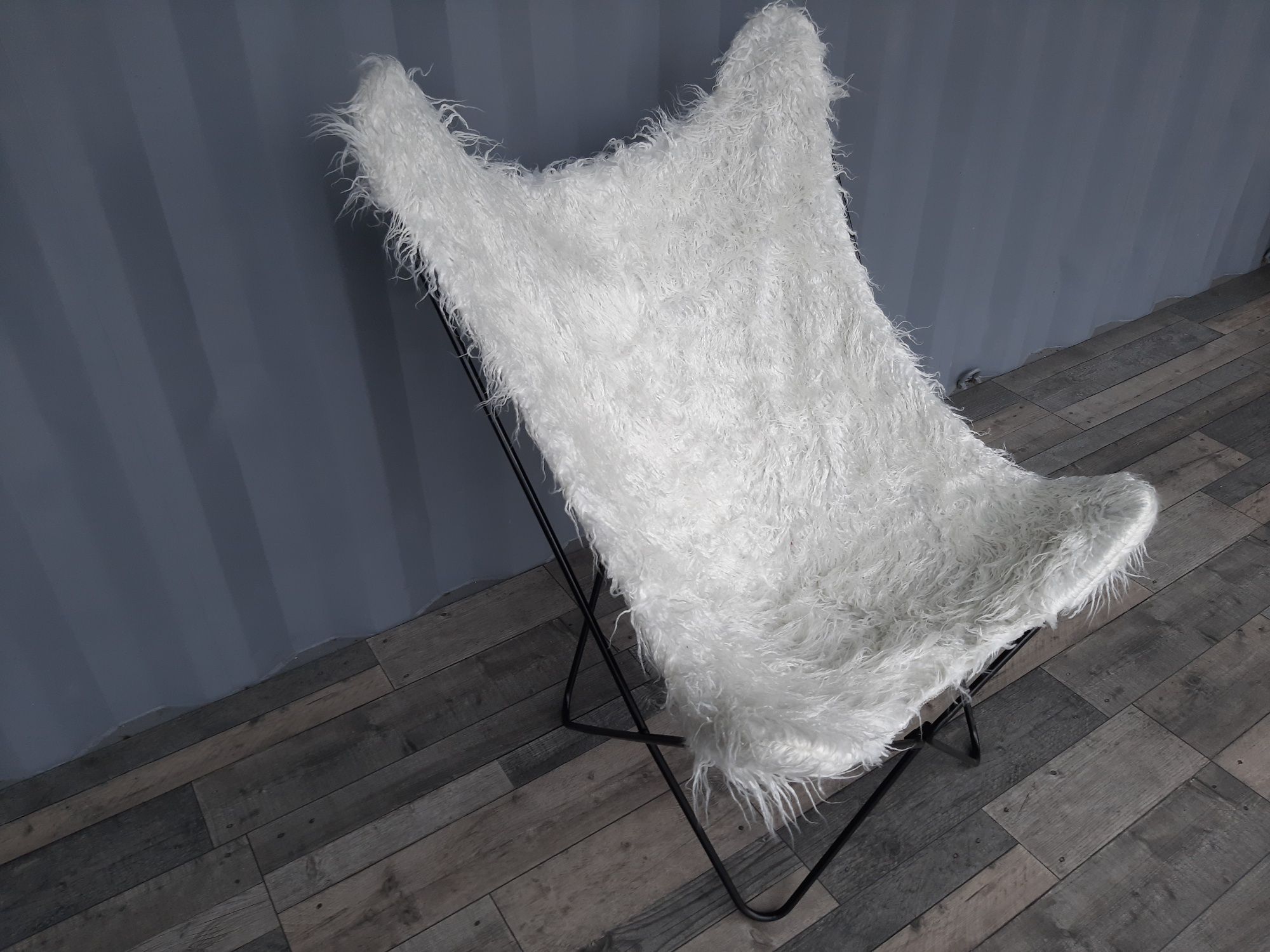 Biały włochaty fotel na metalowej ramie