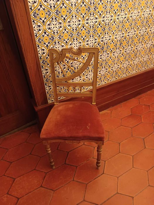 Cadeira antiga com acabamento dourado
