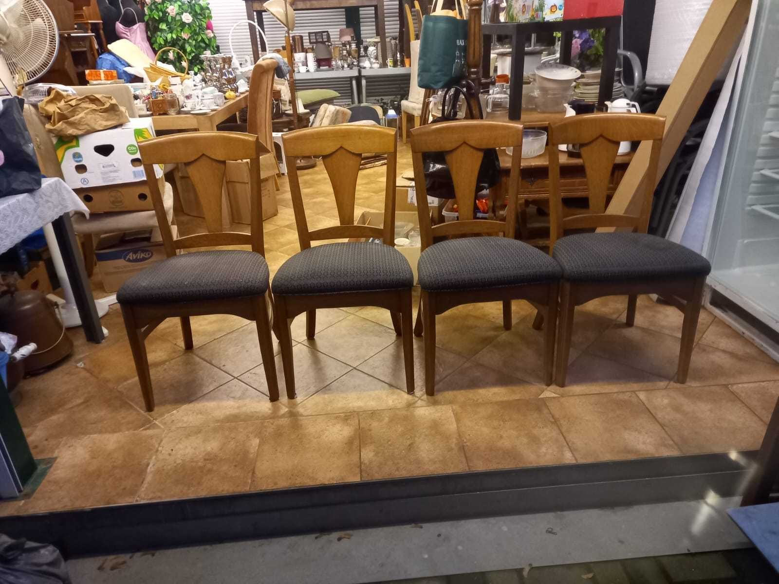 Cztery krzesła w kolorze jasnego drewna.