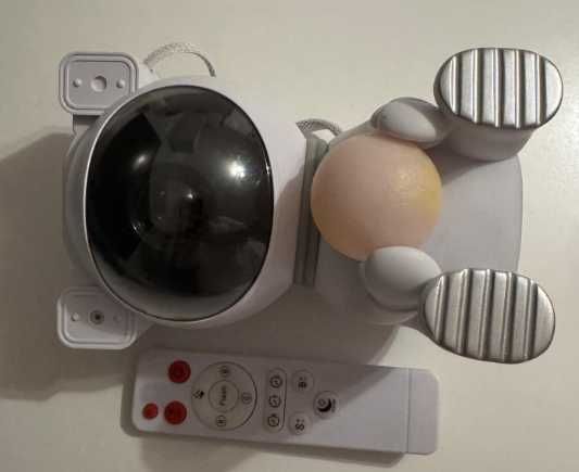 Siedzący astronauta, projektor gwiazd, sterowanie pilotem