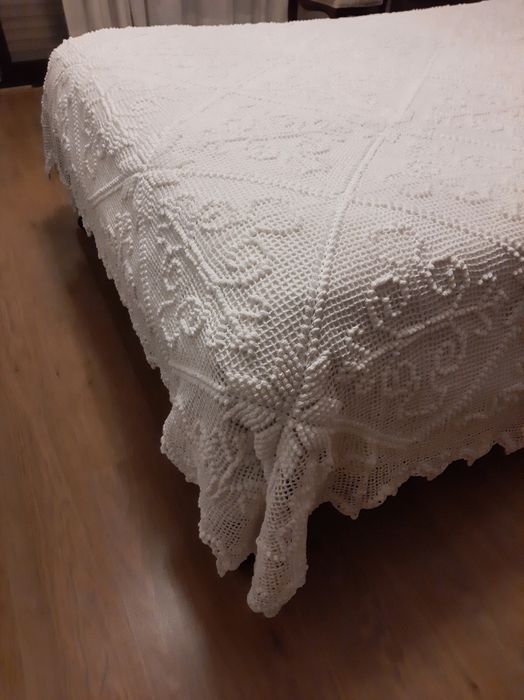 Colcha branca de renda feita à  mão .