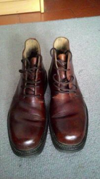 Dois pares botas em pele um pretas, outro castanhas