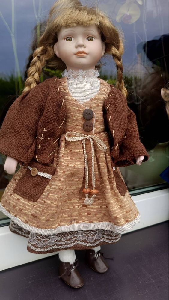 Porcelanowa lalka w brązowej sukience