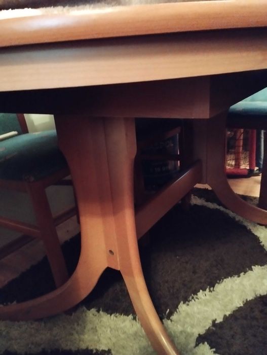 Owalny, rozkładany stół do salonu lub jadalni z krzesłami.